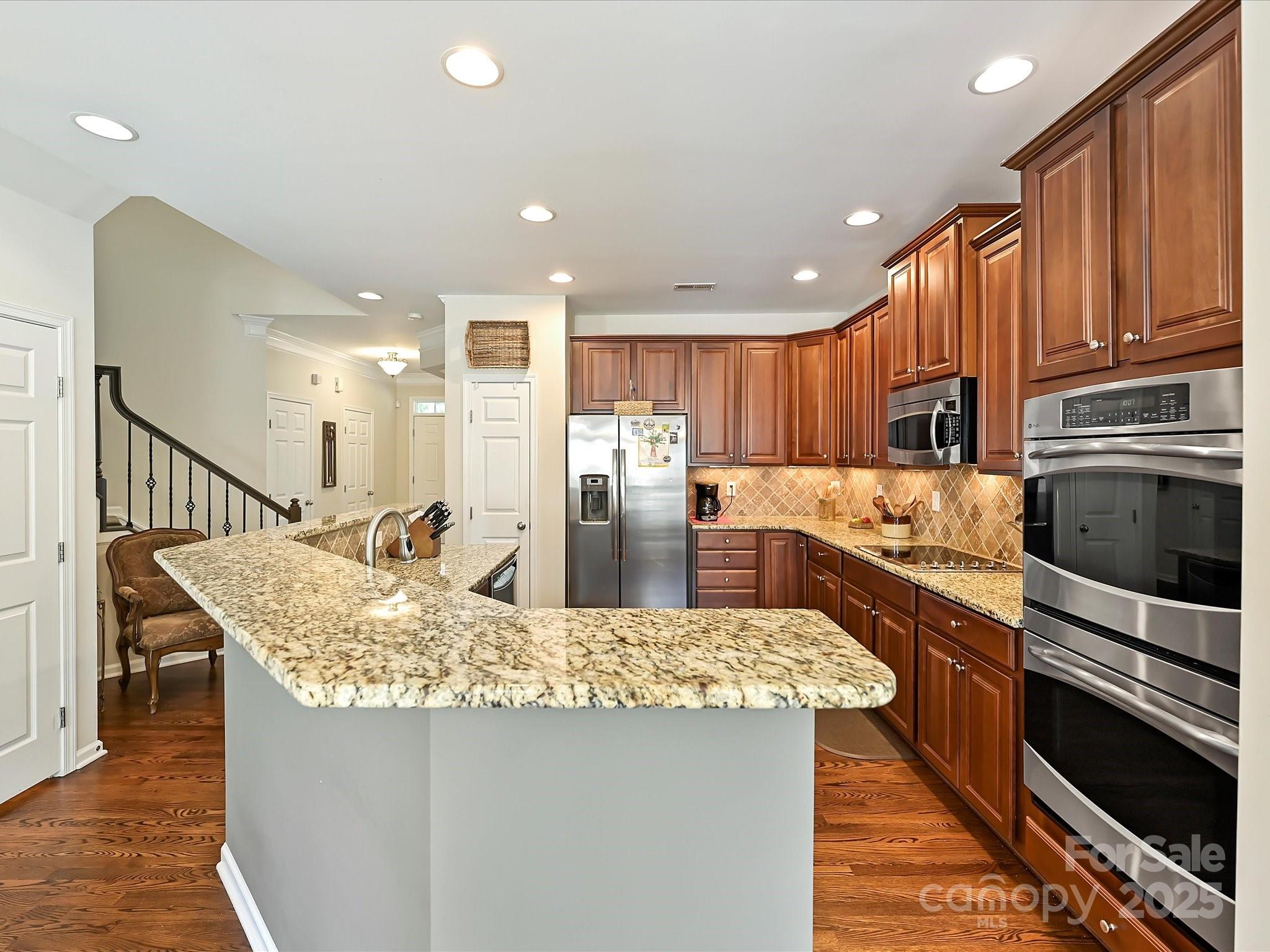 405 Armour Street Davidson, NC 28036 - Photo 9 of 33 a kitchen with kitchen island granite countertop wooden cabinets and stainless steel appliances