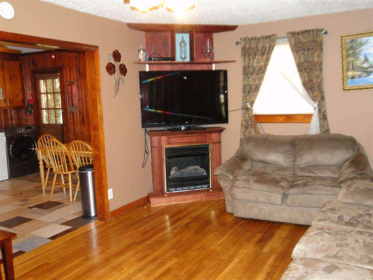 3911 Cheek Road Durham, NC 27704 - Photo 2 of 17 a living room with furniture a flat screen tv and a fireplace