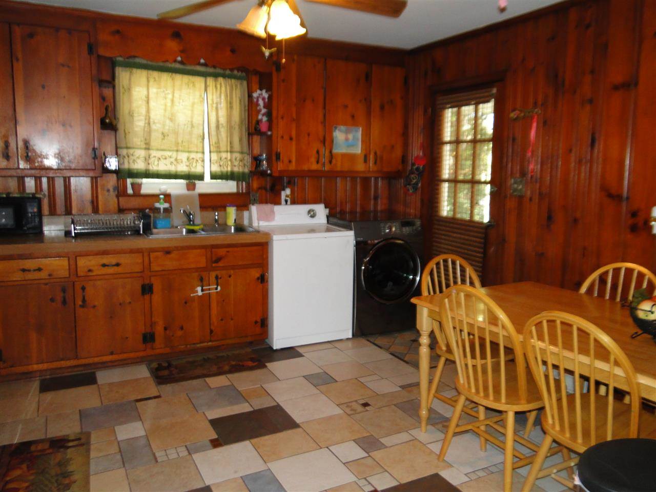 3911 Cheek Road Durham, NC 27704 - Photo 11 of 17 a kitchen with a sink a stove cabinets and dining table