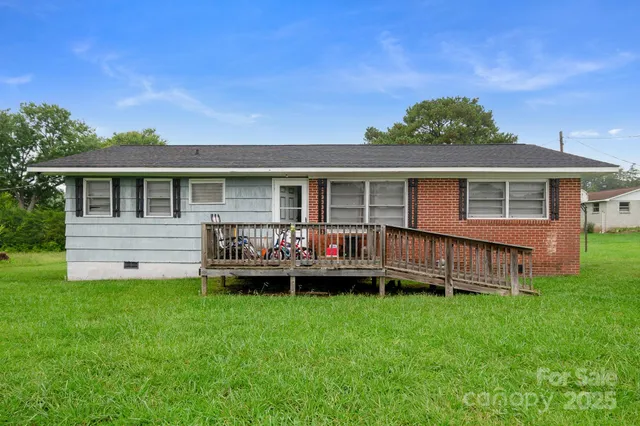 a backyard of a house with wooden deck and barbeque oven
