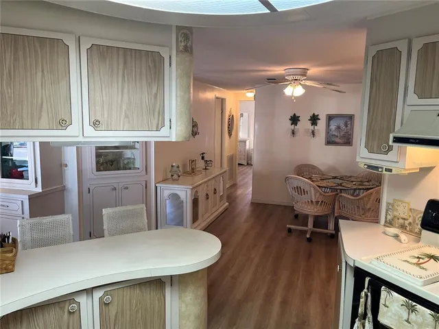 a kitchen with stainless steel appliances kitchen island granite countertop a table chairs in it and wooden floors