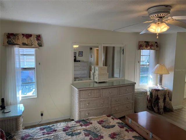 a bedroom with a bed and a mirror on dresser
