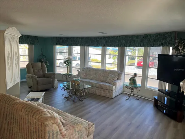 a living room with furniture and a flat screen tv with wooden floor