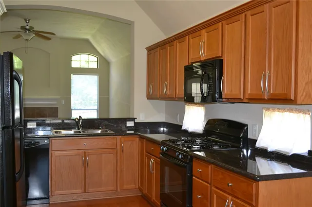 a kitchen with stainless steel appliances granite countertop a stove a sink and a microwave