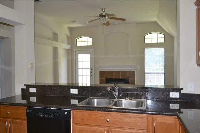 a kitchen with granite countertop a sink stainless steel appliances and cabinets
