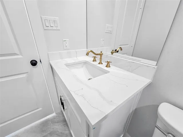 a bathroom with a sink a toilet and a mirror