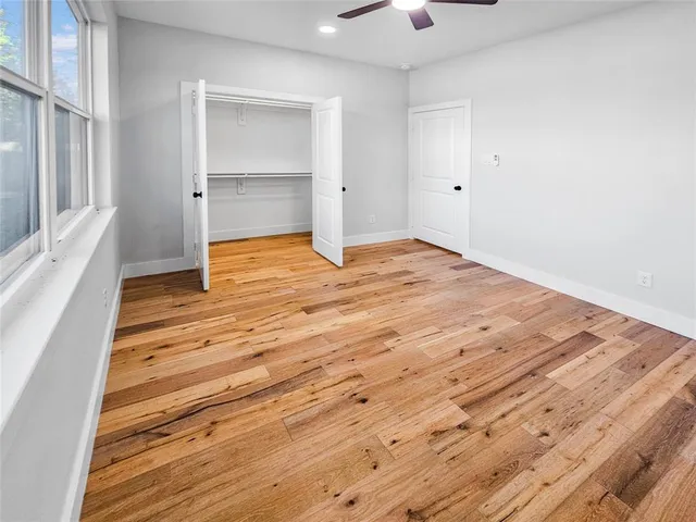 a view of empty room with wooden floor and window
