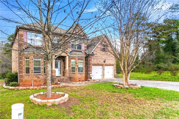 a backyard of a house with a fountain and a large tree