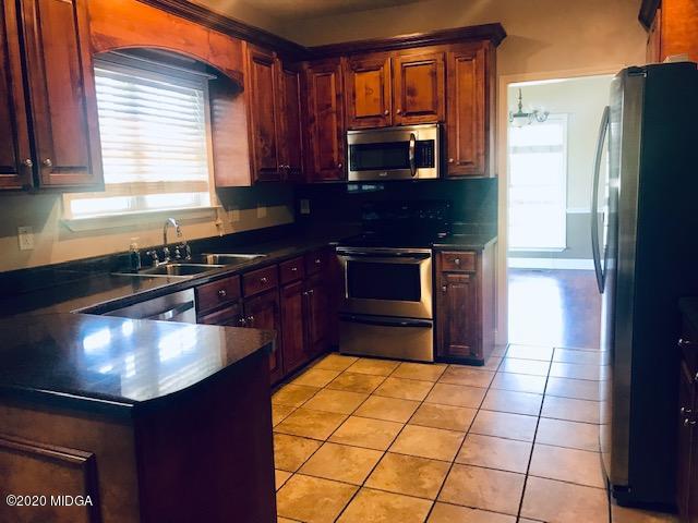 174 Rifle Range Road Gray, GA 31032 - Photo 12 of 39 a kitchen with stainless steel appliances granite countertop a stove a sink and a microwave