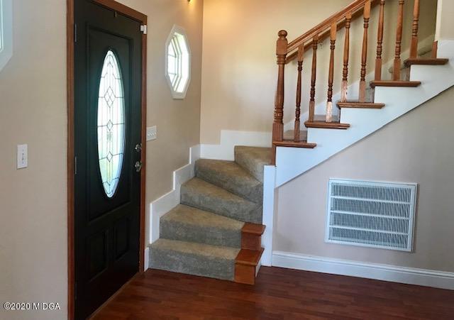174 Rifle Range Road Gray, GA 31032 - Photo 5 of 39 a view of staircase with lots of frames on wall and wooden floor