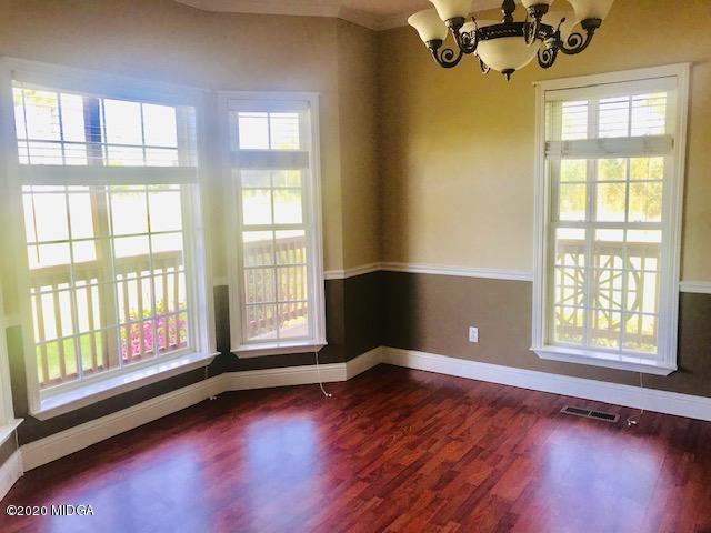 174 Rifle Range Road Gray, GA 31032 - Photo 7 of 39 a view of an empty room with a window and wooden floor