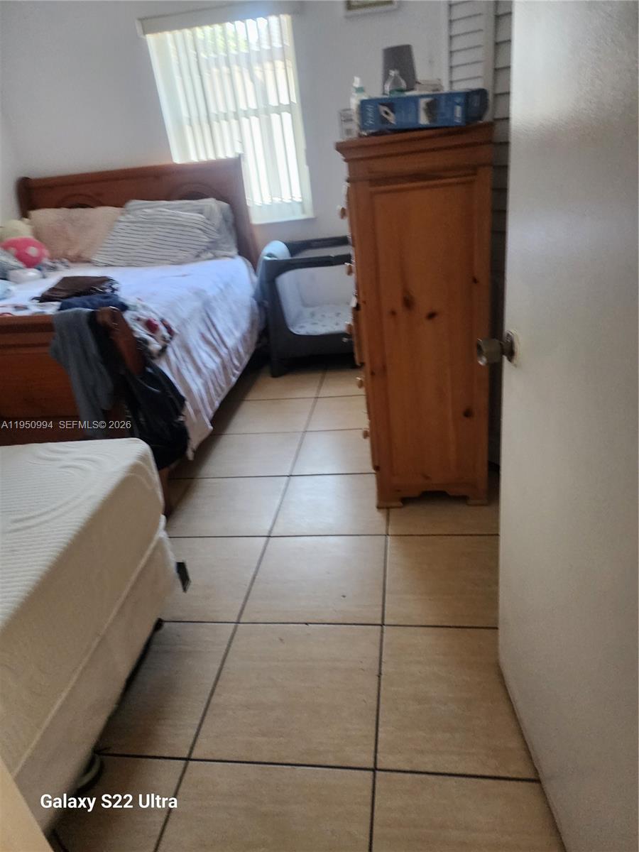 1747 Northwest 85th Street Miami, FL 33147 - Photo 12 of 12 a bedroom with a bed and wooden floor