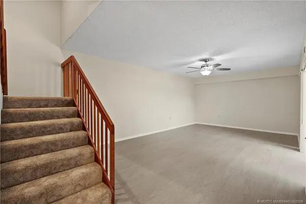 a view of a hallway with wooden floor and chandelier