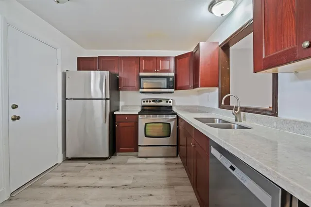 a kitchen with a refrigerator sink and stove top oven
