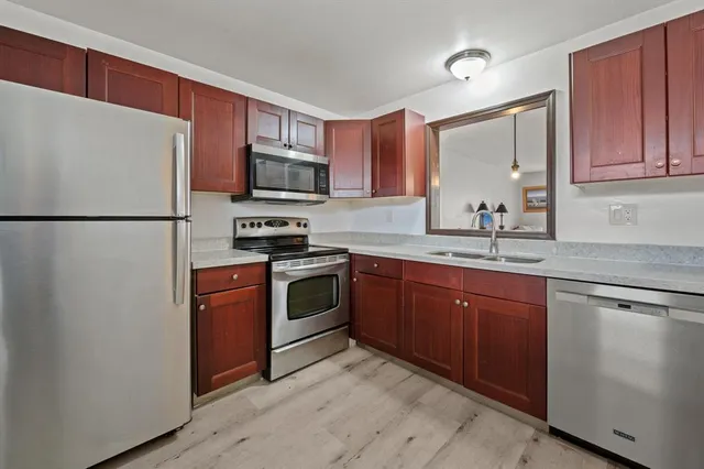 a kitchen with stainless steel appliances granite countertop a refrigerator stove a sink dishwasher and microwave