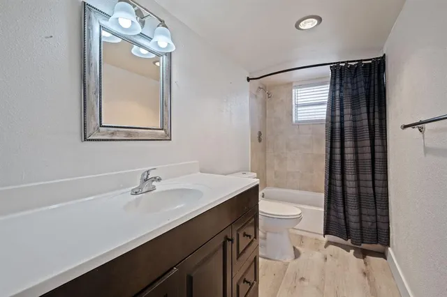 a bathroom with a sink a toilet a mirror and shower