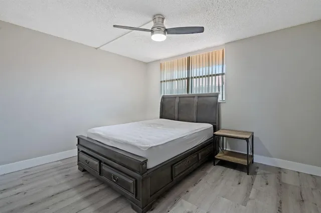 a bedroom with a bed and a ceiling fan