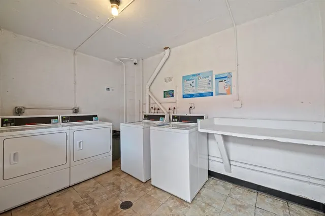 a view of cabinets a sink dishwasher and a stove in a white room