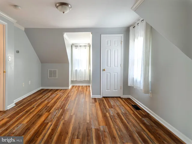a view of a room with wooden floor and window