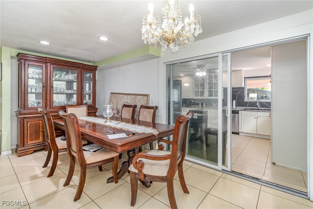 18 Illinois Road Lehigh Acres, FL 33936 - Photo 18 of 28 a dining room with furniture a chandelier and wooden floor