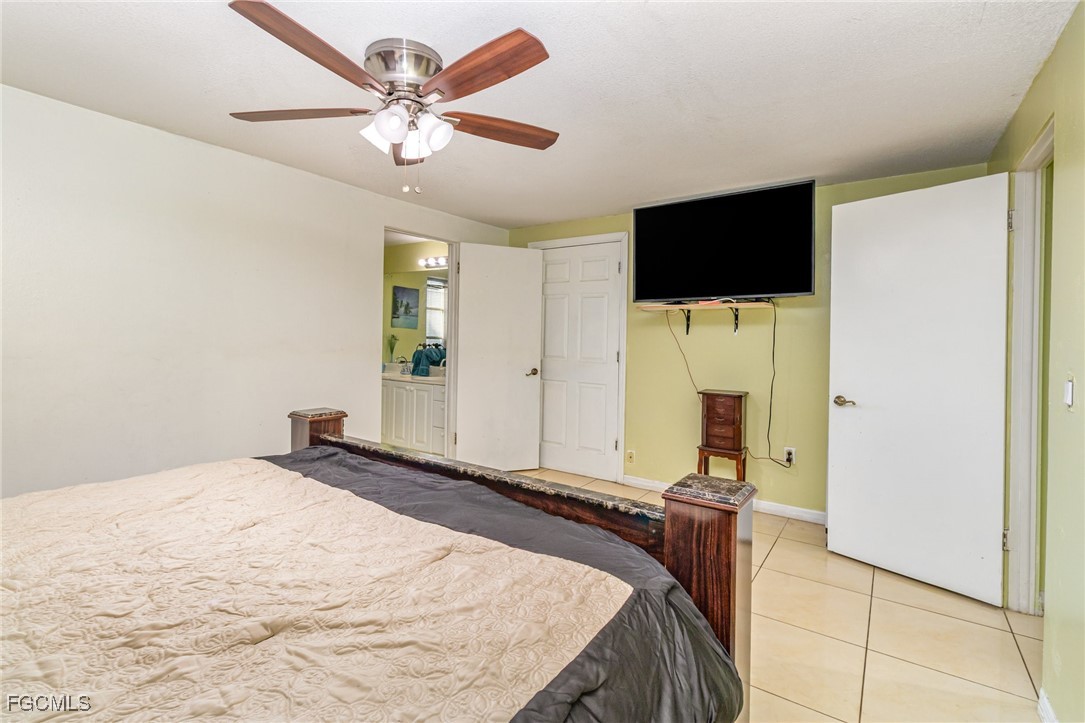 18 Illinois Road Lehigh Acres, FL 33936 - Photo 21 of 28 a bedroom with a bed and a flat screen tv