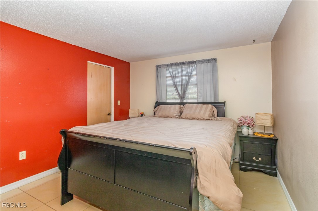 18 Illinois Road Lehigh Acres, FL 33936 - Photo 26 of 28 a bedroom with a bed and a window