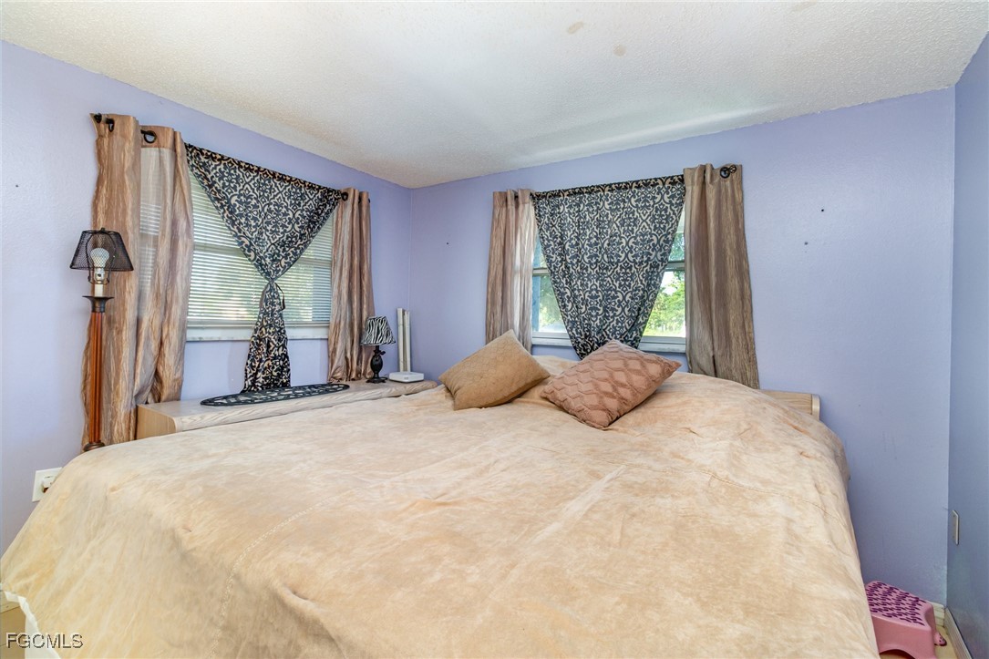 18 Illinois Road Lehigh Acres, FL 33936 - Photo 27 of 28 a bedroom with a large bed and a window