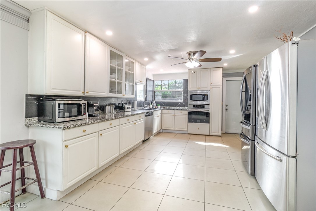 18 Illinois Road Lehigh Acres, FL 33936 - Photo 6 of 28 a kitchen with stainless steel appliances a refrigerator sink and cabinets