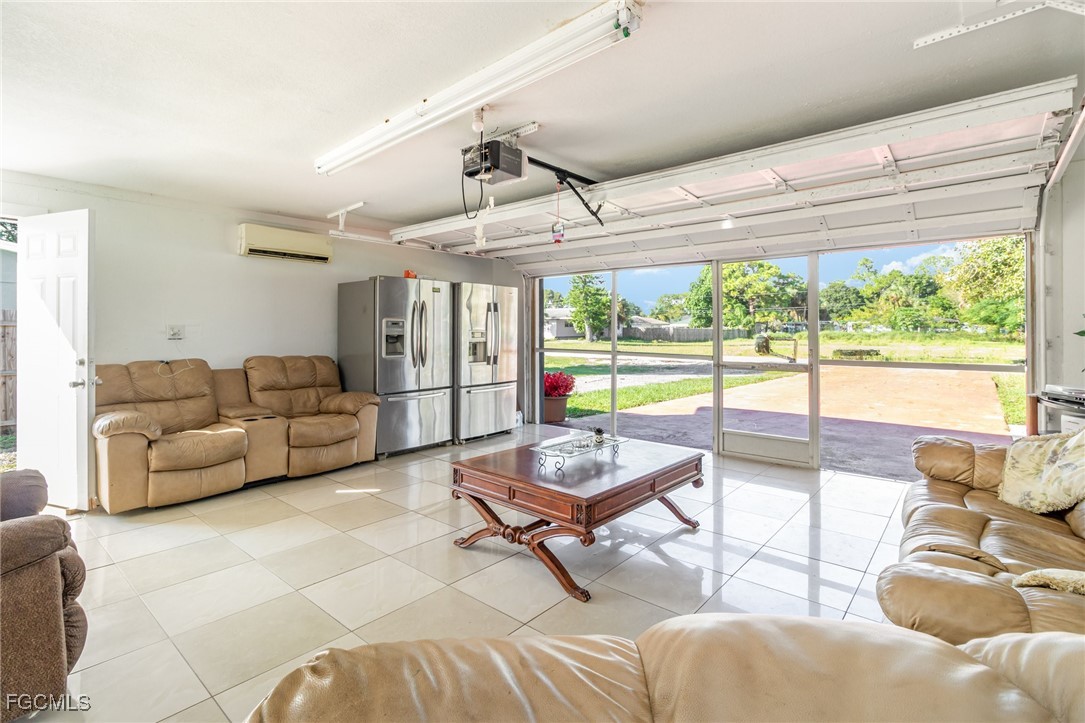 18 Illinois Road Lehigh Acres, FL 33936 - Photo 9 of 28 a living room with furniture and a floor to ceiling window