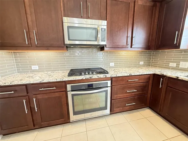 a kitchen with granite countertop a sink and a stove