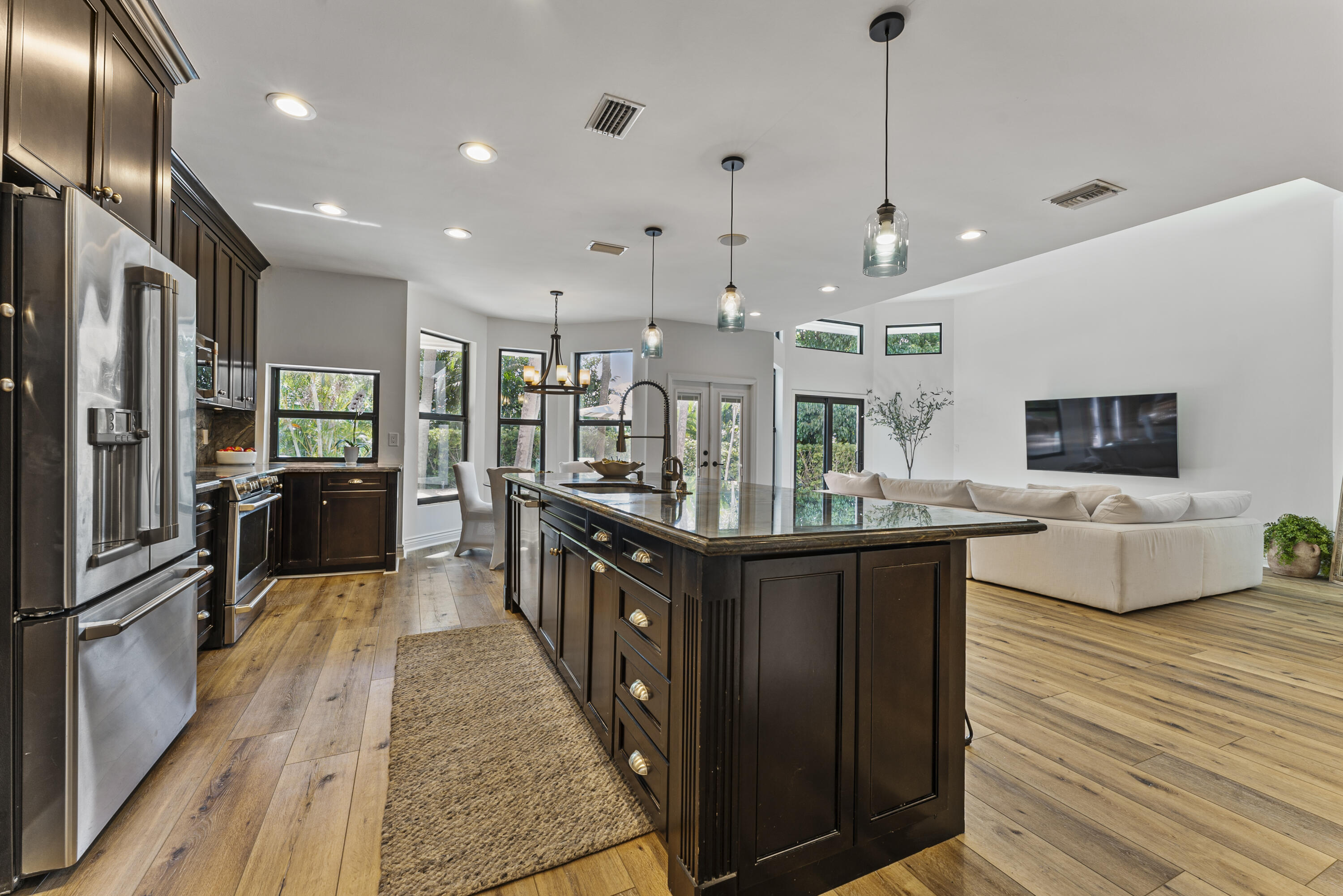 1925 Parkside Circle South Boca Raton, FL 33486 - Photo 18 of 61 a kitchen with stainless steel appliances granite countertop a refrigerator a sink dishwasher a oven and a dining table with wooden floor
