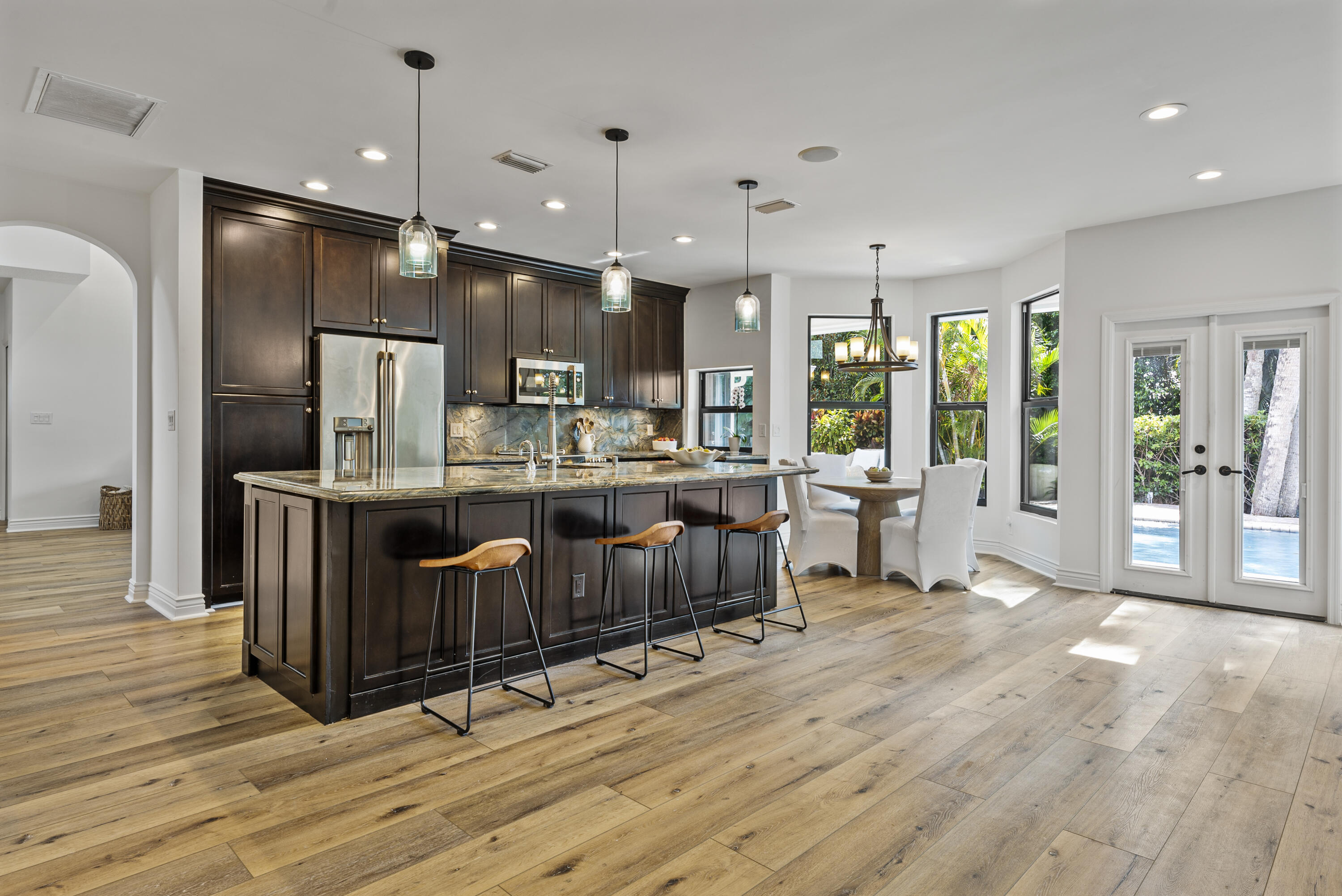 1925 Parkside Circle South Boca Raton, FL 33486 - Photo 20 of 61 a open kitchen with stainless steel appliances kitchen island granite countertop a refrigerator a oven a sink with island and chairs