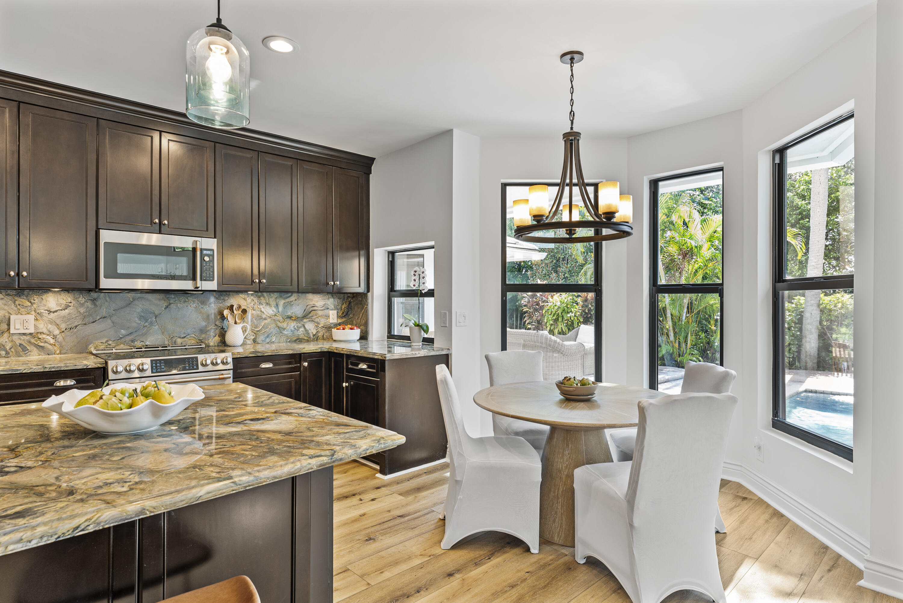 1925 Parkside Circle South Boca Raton, FL 33486 - Photo 21 of 61 a kitchen with a stove a sink a kitchen island a dining table and chairs