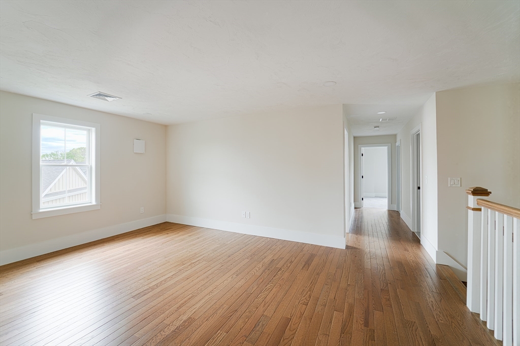 20 Metacomet Road, Unit 20 West Bridgewater, MA 02379 - Photo 18 of 30 a view of an empty room with wooden floor and a window