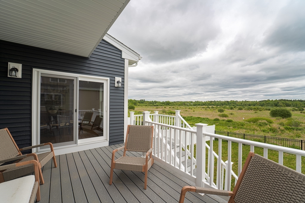 20 Metacomet Road, Unit 20 West Bridgewater, MA 02379 - Photo 28 of 30 a view of a balcony with wooden floor next to a yard