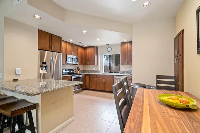 a kitchen with stainless steel appliances granite countertop a sink refrigerator and cabinets