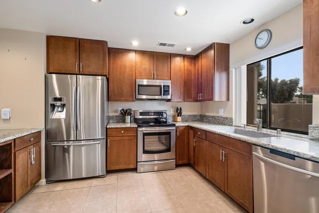 a kitchen with stainless steel appliances granite countertop a refrigerator sink and microwave