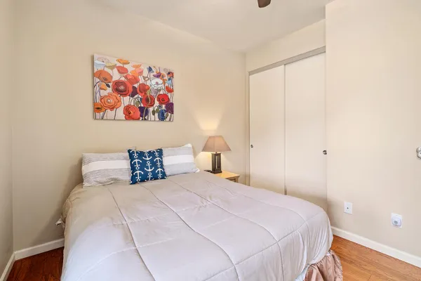 a bedroom with a large bed and a painting on the wall