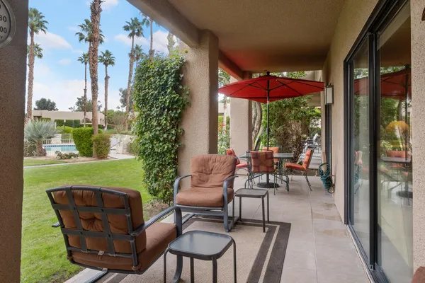 a view of a chairs and table in patio with a yard