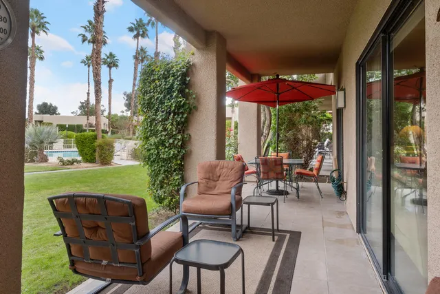 a view of a chairs and table in patio with a yard