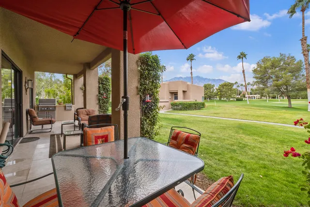 a view of a patio with a table chairs and a backyard