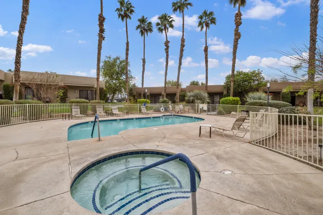 a view of a swimming pool with a patio and a lawn chairs