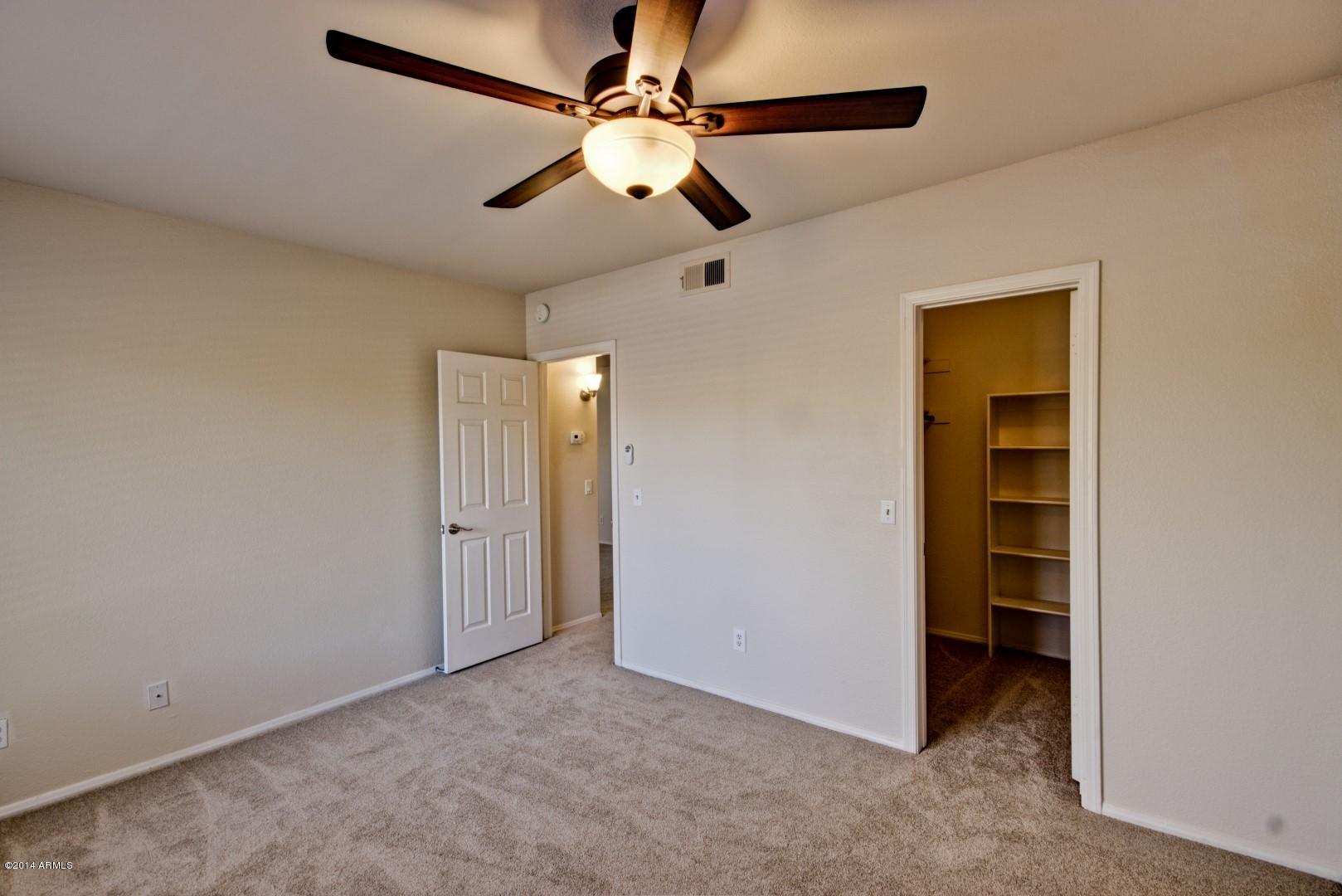1825 West Ray Road, Unit 2055 Chandler, AZ 85224 - Photo 12 of 28 an empty room with closet and a ceiling fan