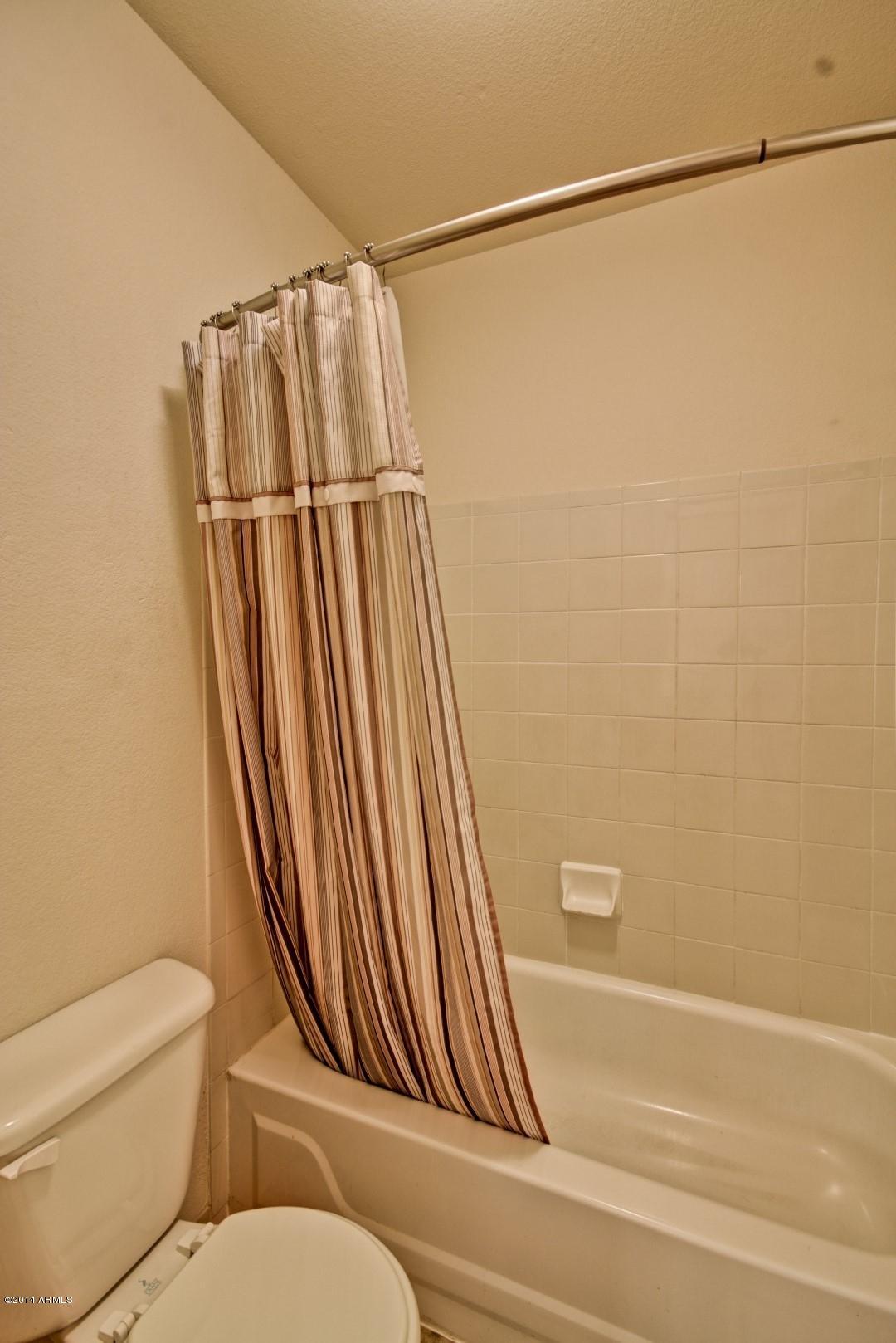 1825 West Ray Road, Unit 2055 Chandler, AZ 85224 - Photo 14 of 28 a bathroom with a toilet and a bathtub