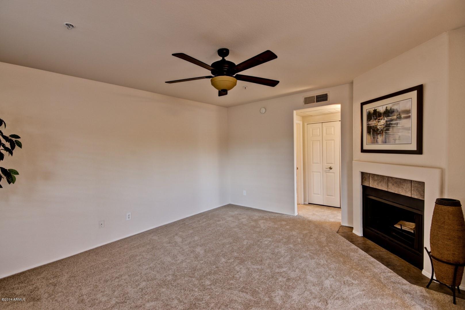 1825 West Ray Road, Unit 2055 Chandler, AZ 85224 - Photo 2 of 28 a view of a livingroom with a ceiling fan and fireplace
