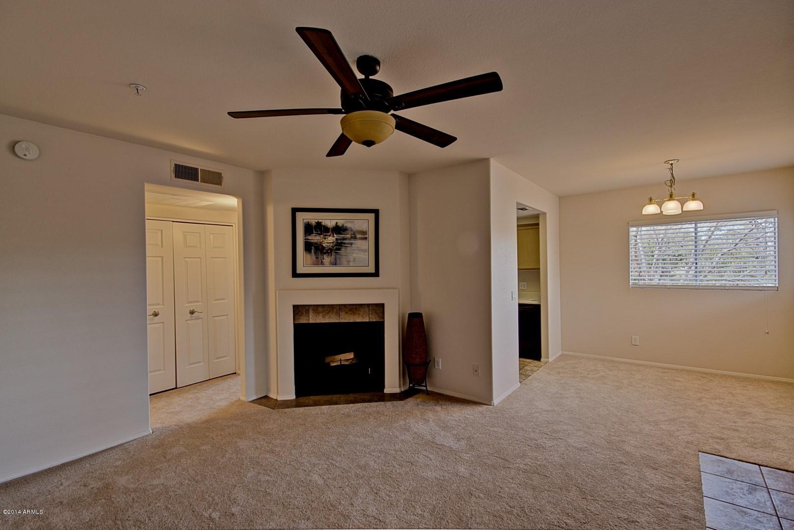 1825 West Ray Road, Unit 2055 Chandler, AZ 85224 - Photo 3 of 28 a living room with a ceiling fan and a fireplace