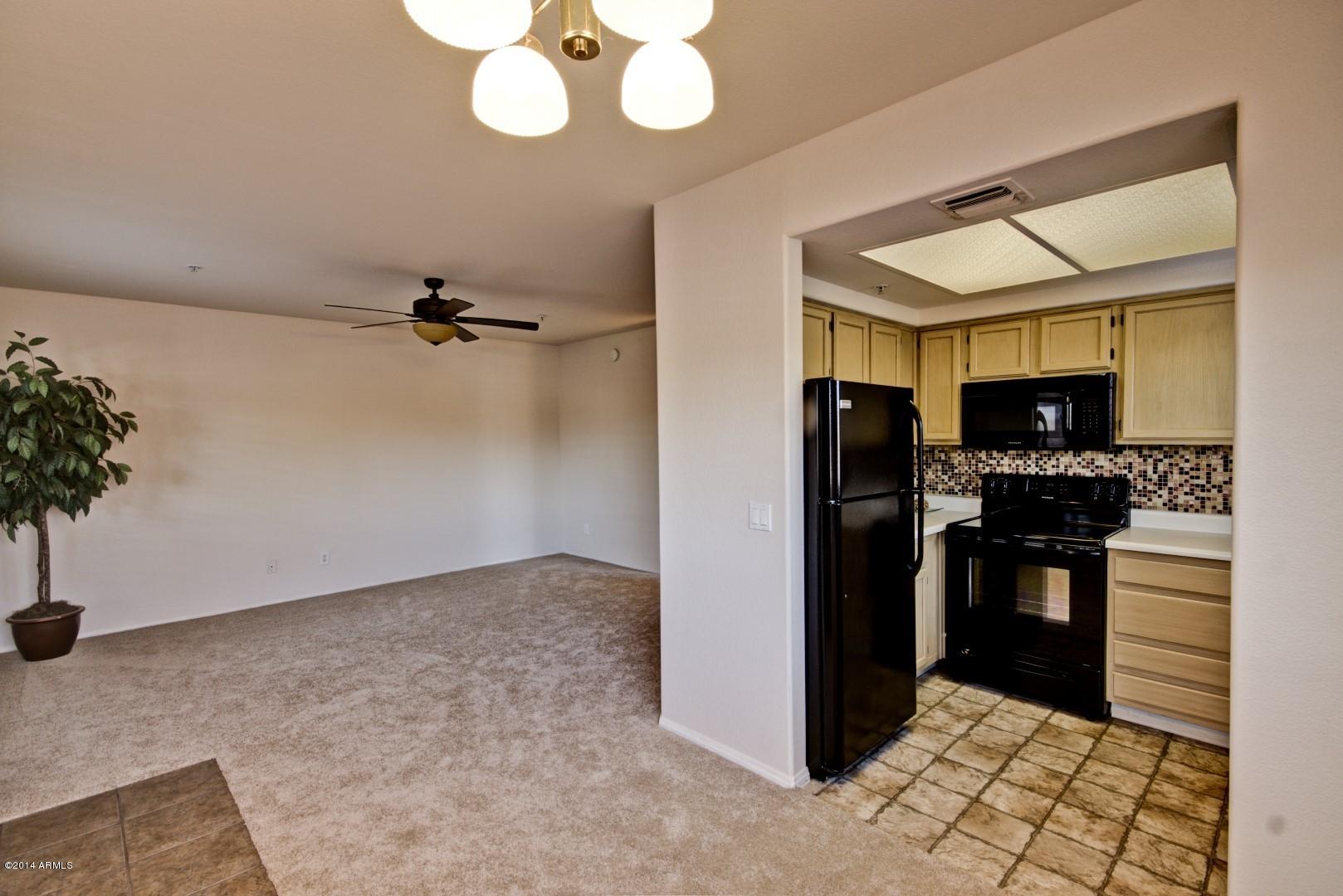 1825 West Ray Road, Unit 2055 Chandler, AZ 85224 - Photo 6 of 28 a kitchen with a refrigerator and cabinets