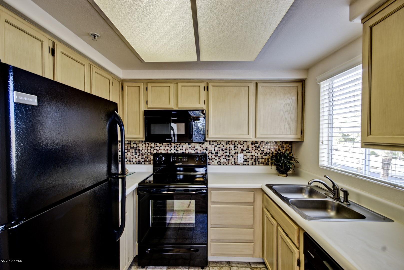 1825 West Ray Road, Unit 2055 Chandler, AZ 85224 - Photo 7 of 28 a kitchen with a sink stove and refrigerator
