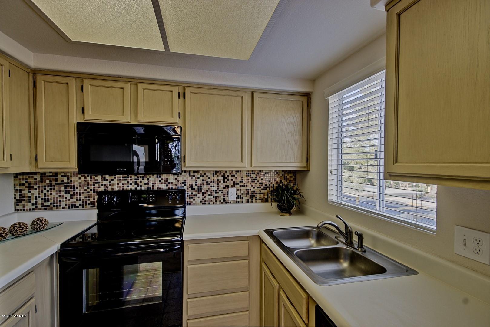 1825 West Ray Road, Unit 2055 Chandler, AZ 85224 - Photo 8 of 28 a kitchen with a sink and a stove top oven