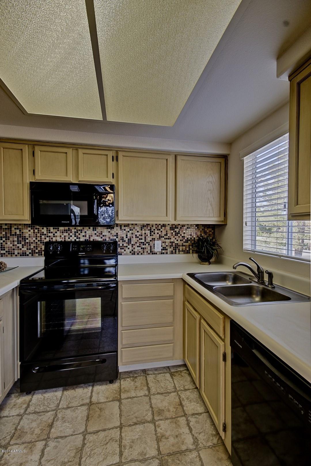 1825 West Ray Road, Unit 2055 Chandler, AZ 85224 - Photo 9 of 28 a kitchen with stainless steel appliances a stove sink and cabinets